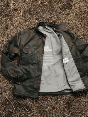 Cairn British-made waxed cotton overshirt in Raven laid open showing the grey lining and internal details