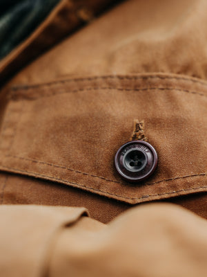 Close-up of corozo button and stitching on the Cairn British-made waxed cotton overshirt in Whisky
