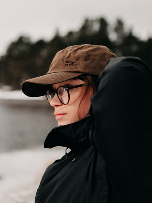 Demi, wife of Bear&Wolf founder Jake, wearing the Wax Cap in Field Brown in the Scottish countryside.