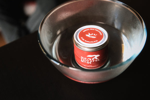 Old Faithful No.01 wax treatment tin sitting in a bowl of hot water to soften the wax before reproofing a Cairn Overshirt.