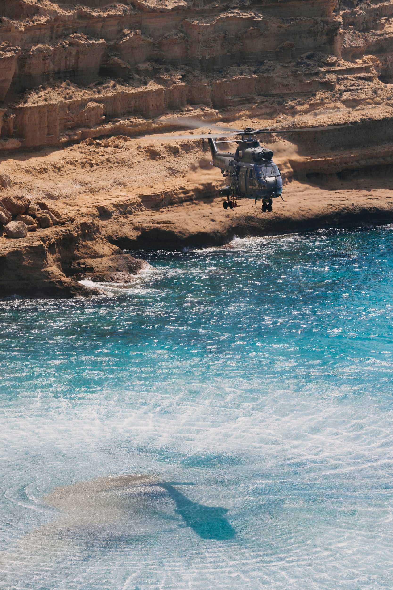 RAF Puma helicopter flying low along the rocky Cyprus coastline near RAF Akrotiri