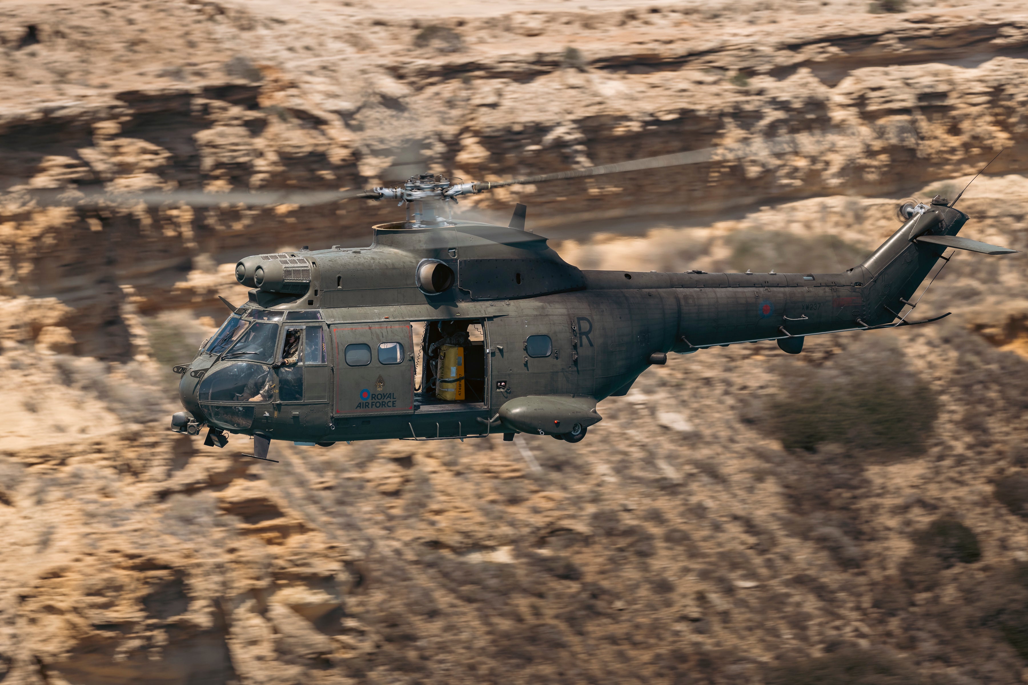 RAF Puma helicopter flying low over the Cyprus landscape during training from RAF Akrotiri