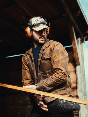 Man wearing The Stac heavyweight wax jacket while handling timber at Moore Timber Co.